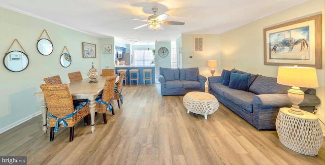 living room featuring wood-type flooring, crown molding, and ceiling fan