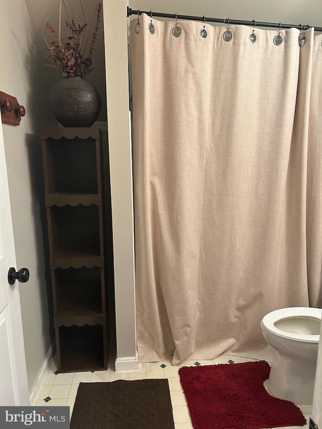 full bath featuring toilet, baseboards, a shower with shower curtain, and tile patterned floors