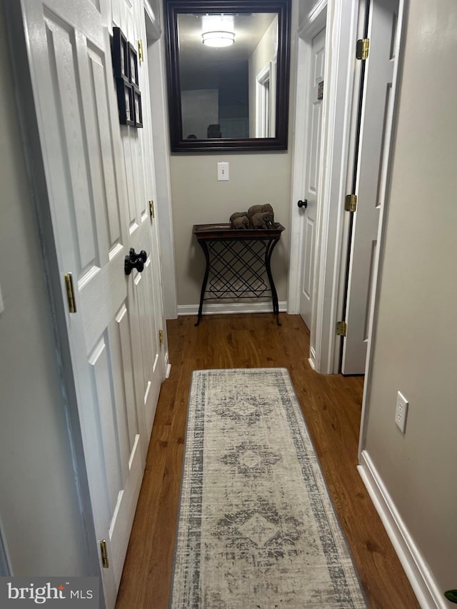 corridor with hardwood / wood-style flooring