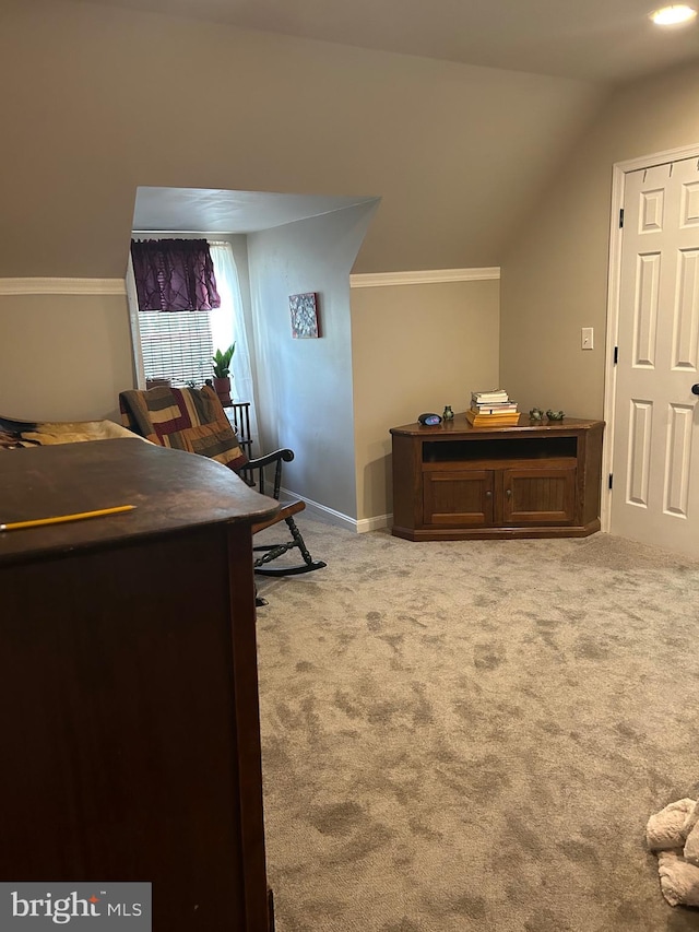 bedroom with light colored carpet and lofted ceiling