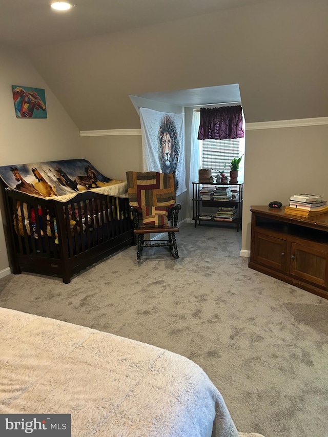 bedroom featuring crown molding, carpet flooring, vaulted ceiling, and a nursery area