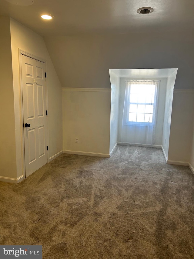 bonus room featuring lofted ceiling, carpet, and baseboards