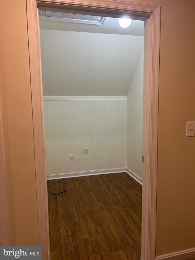 bonus room featuring lofted ceiling, dark wood-style flooring, and baseboards