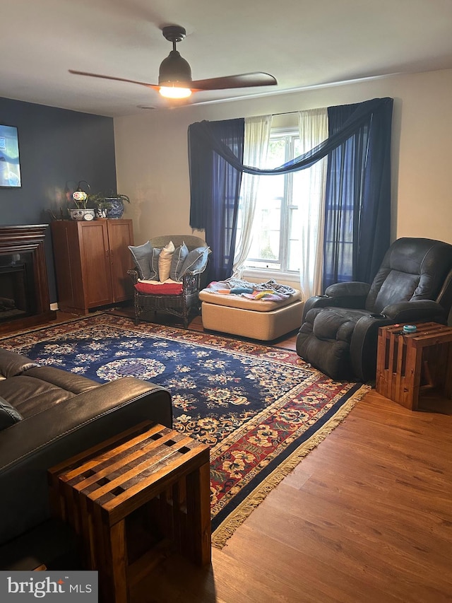 sitting room featuring wood-type flooring and ceiling fan