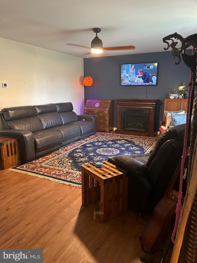 living room featuring ceiling fan and hardwood / wood-style flooring