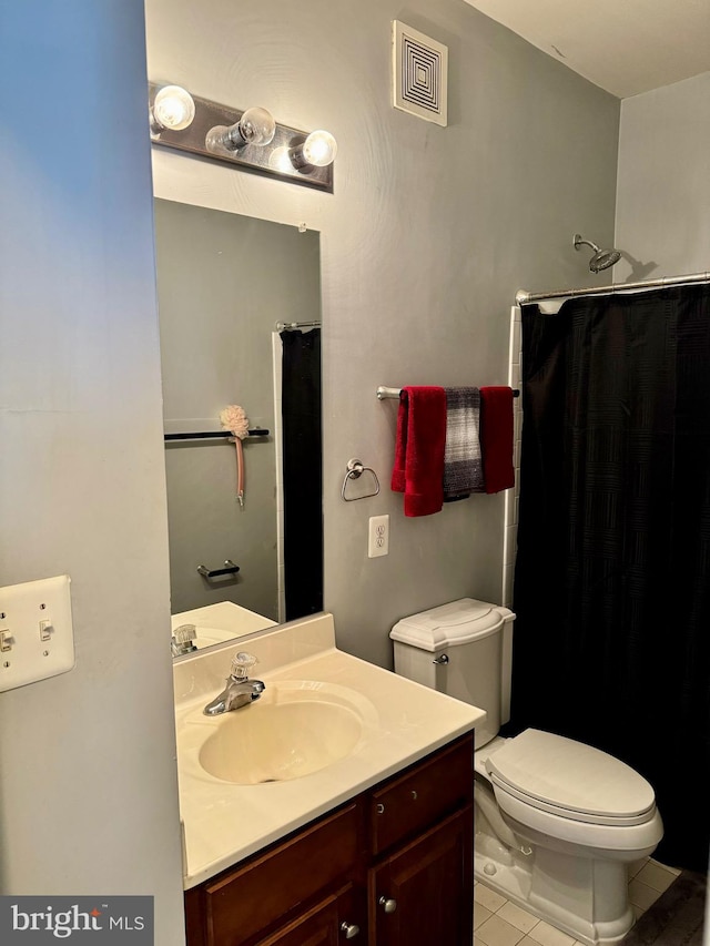 bathroom featuring vanity, toilet, walk in shower, and tile patterned flooring