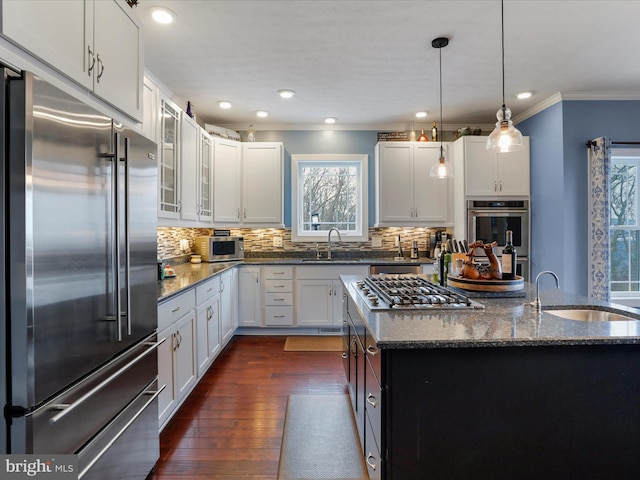 kitchen with white cabinetry, appliances with stainless steel finishes, and dark stone countertops