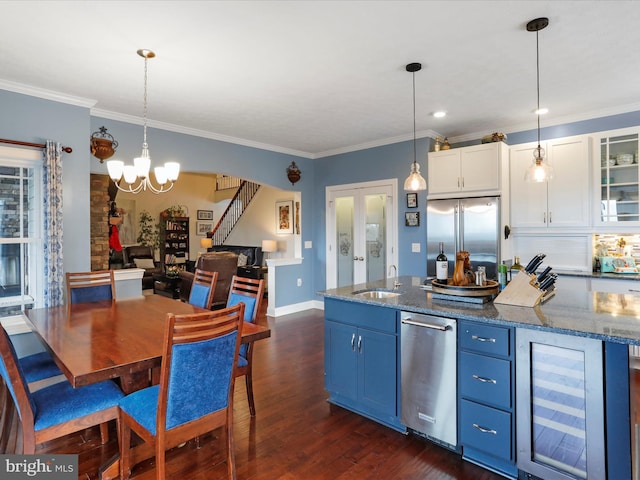 kitchen featuring stainless steel appliances, wine cooler, white cabinets, and decorative light fixtures