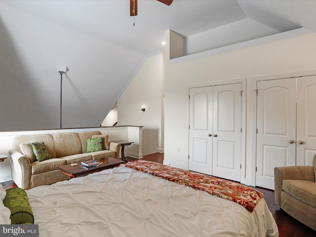 bedroom with multiple closets, ceiling fan, a tray ceiling, and dark wood-type flooring