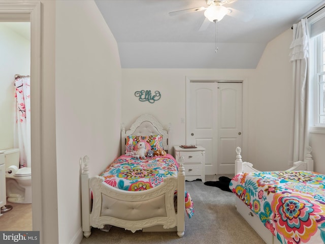 carpeted bedroom with multiple windows, vaulted ceiling, ceiling fan, and a closet