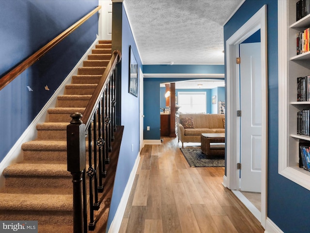 stairway featuring hardwood / wood-style flooring and a textured ceiling