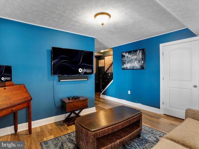 living room featuring wood-type flooring and a textured ceiling