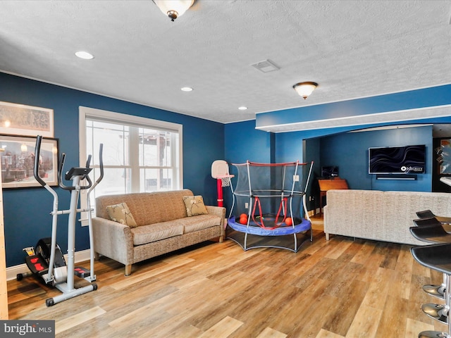 living room featuring wood-type flooring and a textured ceiling