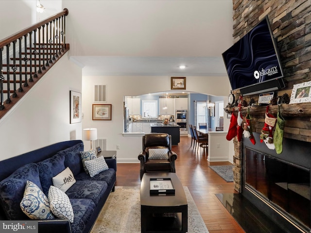 living room featuring a stone fireplace and hardwood / wood-style floors