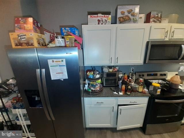 kitchen featuring white cabinetry, hardwood / wood-style floors, and stainless steel appliances