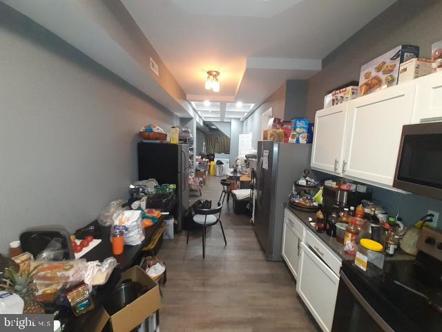 kitchen featuring stainless steel appliances, white cabinets, and dark hardwood / wood-style floors