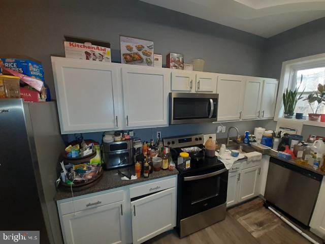 kitchen featuring white cabinetry, hardwood / wood-style floors, and stainless steel appliances