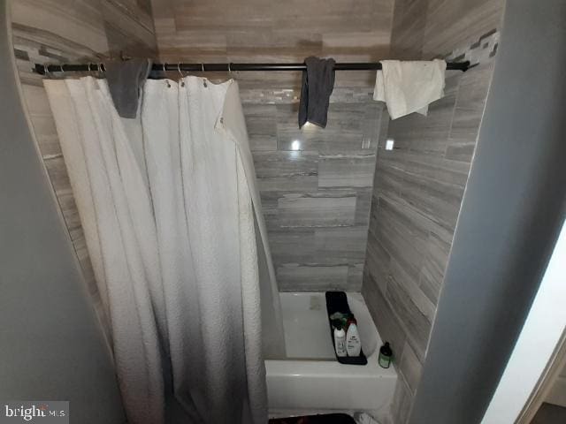 bathroom with shower / bath combination with curtain