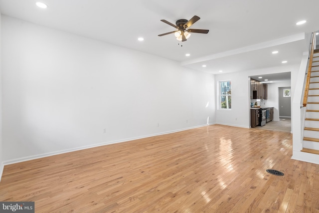 unfurnished living room with light wood-type flooring and ceiling fan