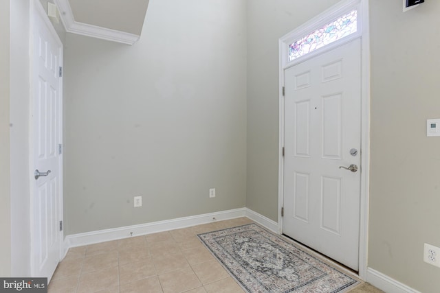 entryway with ornamental molding and light tile patterned floors