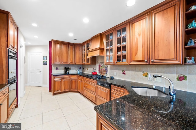 kitchen featuring brown cabinetry, a sink, custom exhaust hood, open shelves, and backsplash