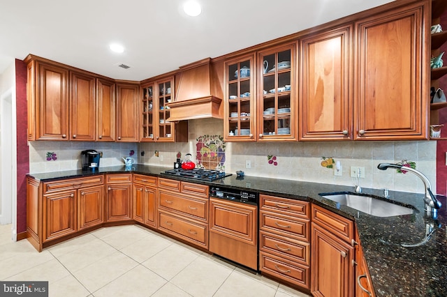 kitchen with custom range hood, visible vents, brown cabinets, and a sink