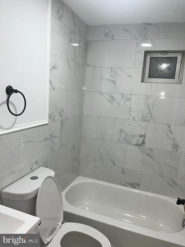 full bathroom featuring tiled shower / bath combo, tile walls, toilet, and vanity