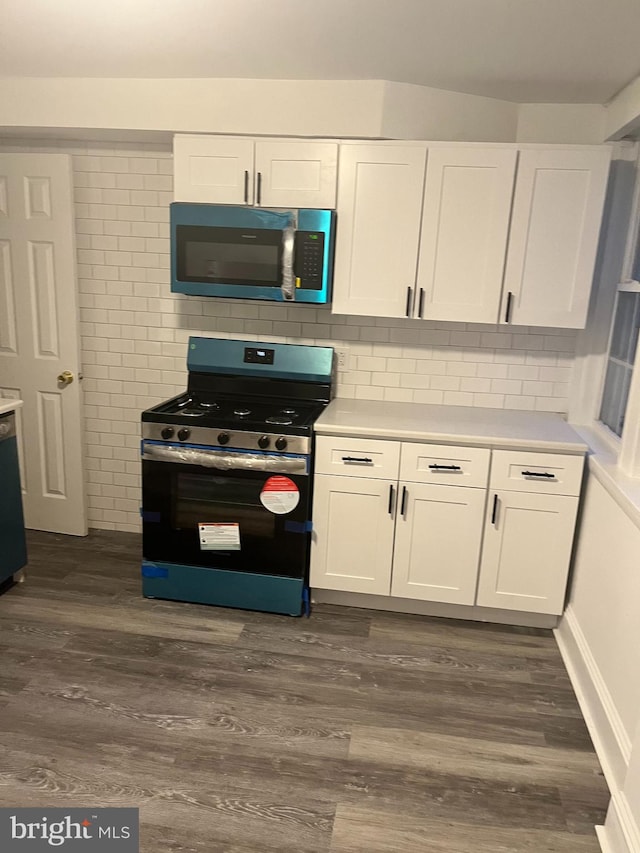 kitchen featuring white cabinets, appliances with stainless steel finishes, and dark hardwood / wood-style flooring