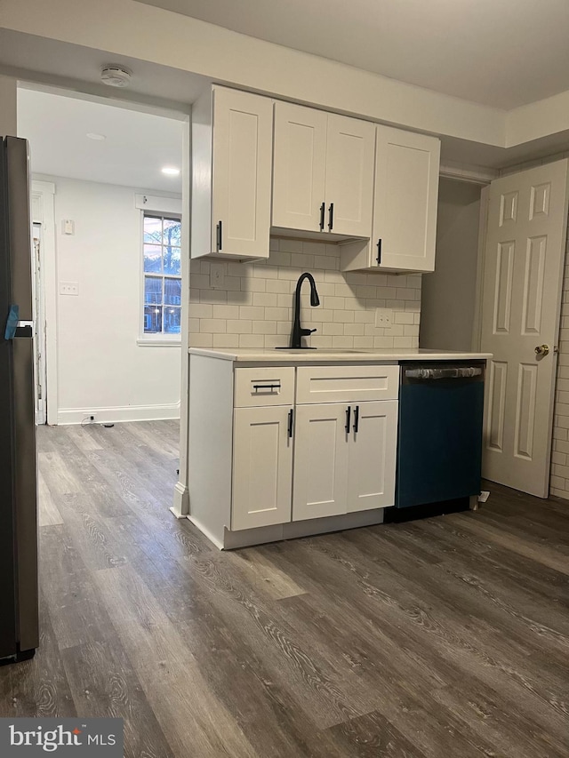 kitchen with black dishwasher, dark wood-type flooring, sink, decorative backsplash, and white cabinetry