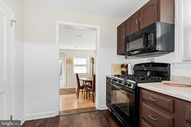 kitchen with dark wood-type flooring and black appliances