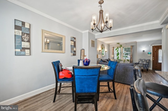 dining area with ornamental molding, a chandelier, and hardwood / wood-style floors