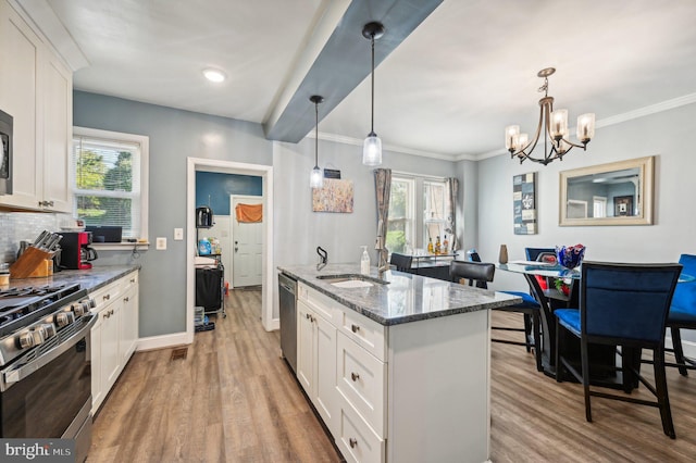 kitchen with decorative light fixtures, dark stone counters, a healthy amount of sunlight, and white cabinetry