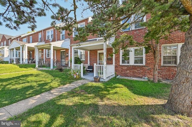 multi unit property featuring a front lawn and covered porch