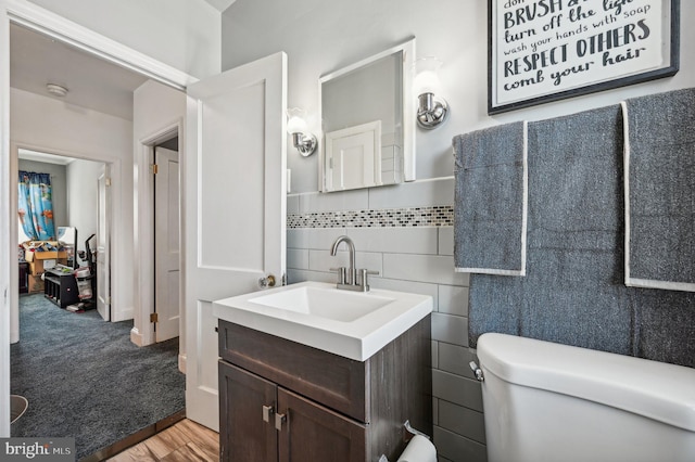 bathroom with vanity, tile walls, hardwood / wood-style floors, and toilet