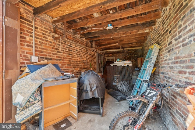 miscellaneous room with concrete floors and brick wall