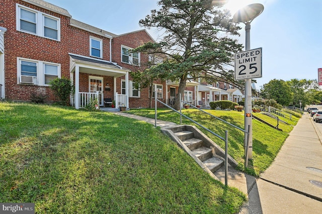 multi unit property with cooling unit, a porch, and a front lawn