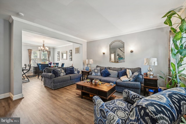 living room featuring an inviting chandelier, hardwood / wood-style flooring, and ornamental molding