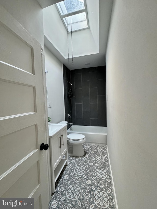 full bathroom with vanity, tile patterned floors, tiled shower / bath, a skylight, and toilet