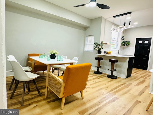 dining room featuring light wood-type flooring, ceiling fan, and sink