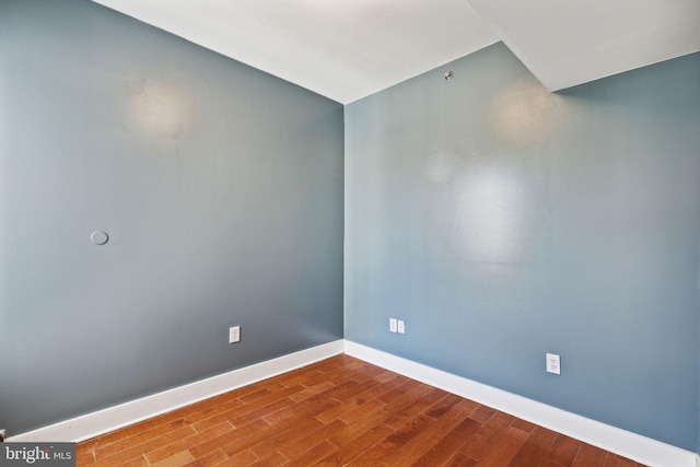 empty room featuring baseboards and wood finished floors