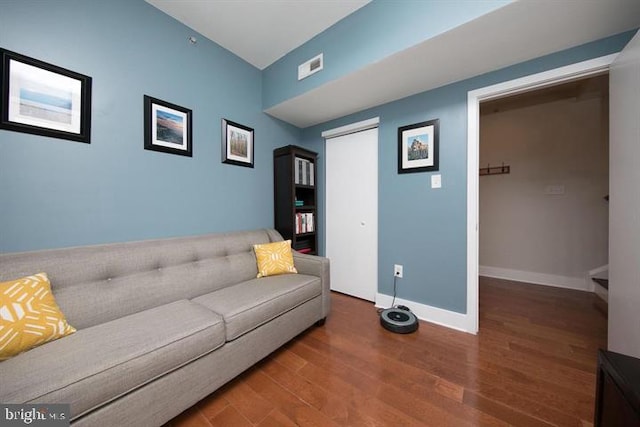 living area with visible vents, baseboards, and wood finished floors