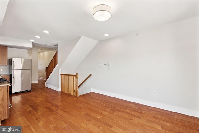 interior space with baseboards, wood finished floors, and recessed lighting