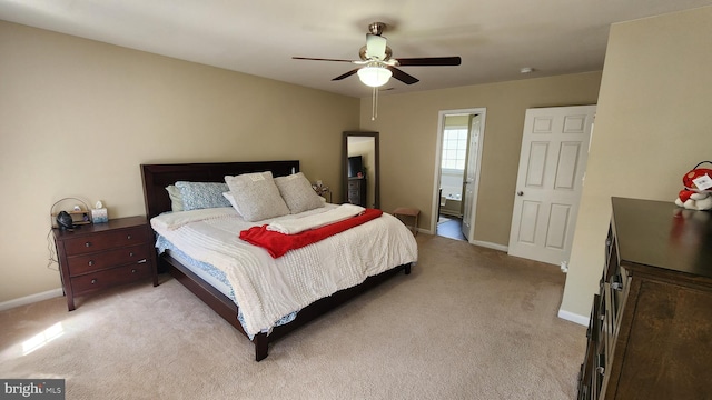 bedroom with light colored carpet, connected bathroom, and ceiling fan