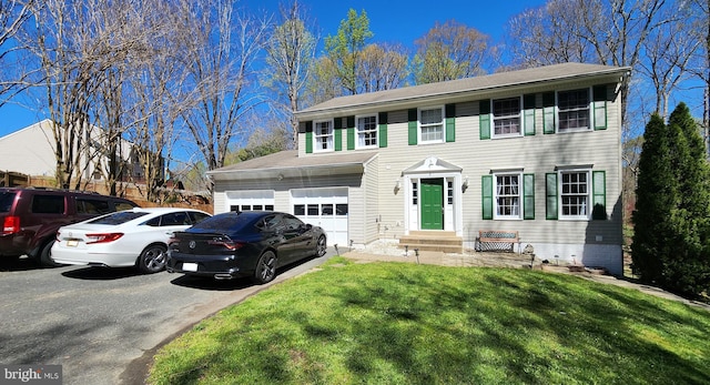 colonial home with a garage and a front yard