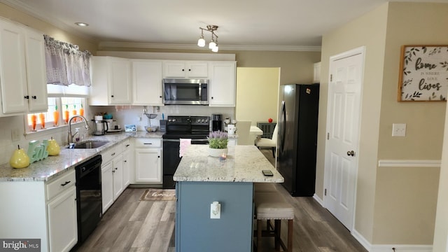 kitchen featuring black appliances, wood-type flooring, a center island, sink, and white cabinets