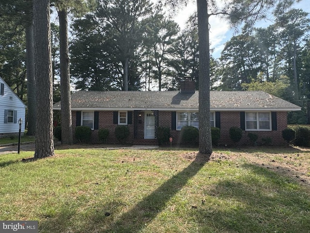 ranch-style house with a front lawn, brick siding, and a chimney