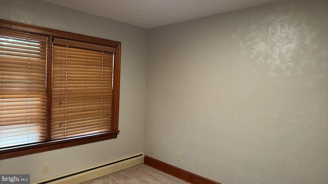 spare room with a baseboard radiator and light carpet