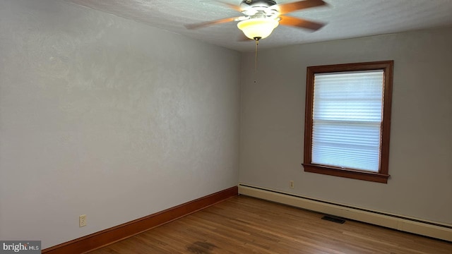 empty room with a baseboard radiator, a textured ceiling, wood-type flooring, and ceiling fan