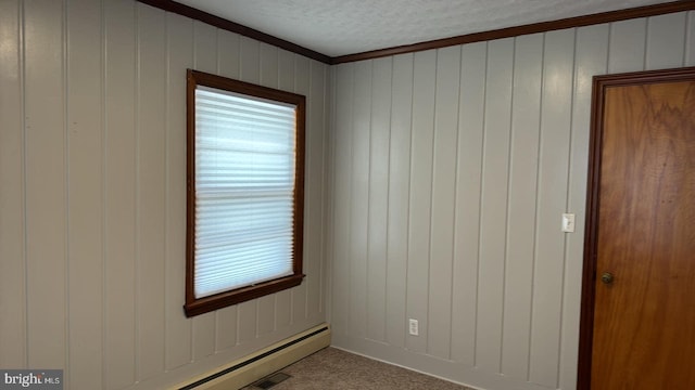 unfurnished room with crown molding, a textured ceiling, a baseboard heating unit, and wooden walls