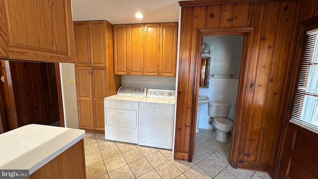 washroom with light tile patterned flooring, cabinet space, and washer and dryer